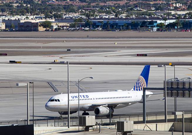 A United passenger jet taxis to a gate after landing at McCarran International Airport Sunday, Oct. 11, 2015.