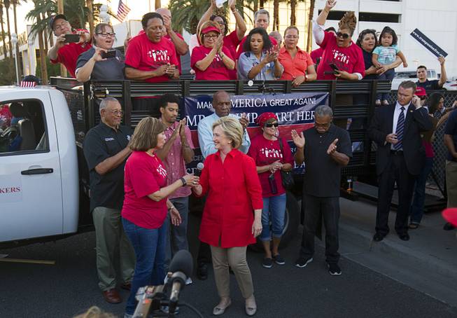 Democratic presidential candidate and former Secretary of State Hillary Clinton, right, hands the microphone to Geoconda Arguello Kline, secretary-treasurer for Culinary Workers Union, Local 226, after speaking at a Culinary demonstration by the Trump International Hotel Monday, Oct. 12, 2015.