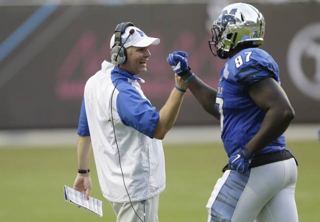 Memphis head coach Justin Fuente congratulates defensive lineman Martin Ifedi (97) after a play during the second half of the in the inaugural Miami Beach Bowl football game against Brigham Young, Monday, Dec. 22, 2014 in Miami. Memphis defeated Brigham Young 55-48 in double overtime.