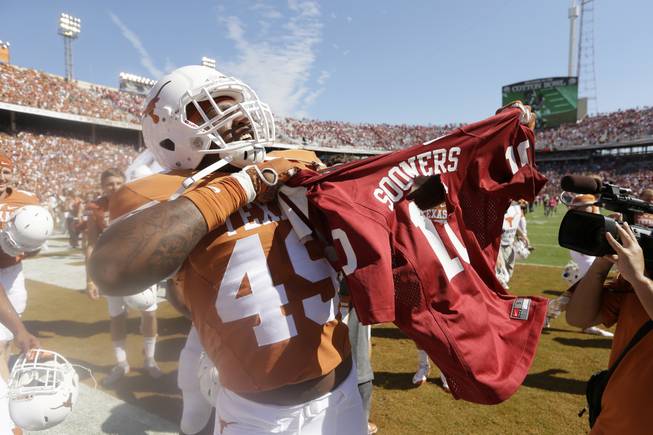 Texas defensive end Derick Roberson (49) rips a Oklahoma jersey after their NCAA college football game Saturday, Oct. 10, 2015, in Dallas.