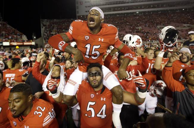 Utah defensive back Dominique Hatfield (15) sits on the shoulders of offensive lineman Isaac Asiata (54) while celebrating with the team after Utah defeated California 30-24 during an NCAA college football game Saturday, Oct. 10, 2015, in Salt Lake City.