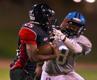 Las Vegas' Diquan Brown, 25, stiff arms Canyon Springs' Juwan Felton, 8, on a tackle attempt during their game on Friday, October 16, 2015. .