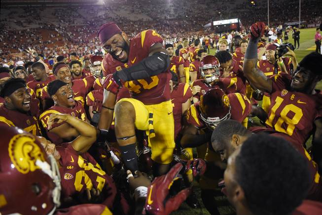 Southern California linebacker Jabari Ruffin, center, celebrates with his team after they defeated Utah in an NCAA college football game, Saturday, Oct. 24, 2015, in Los Angeles. Southern California won 42-24. 