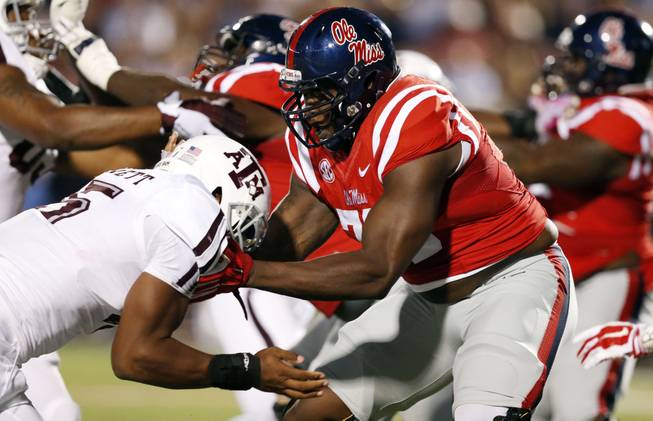 Texas A&M defensive lineman Myles Garrett (15) is locked up by Mississippi offensive lineman Laremy Tunsil (78) during the first half of their NCAA college football game in Oxford, Miss., Saturday, Oct. 24, 2015. No. 24 Mississippi won 23-3.