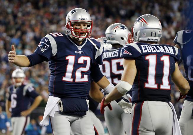 New England Patriots quarterback Tom Brady (12) celebrates his touchdown pass to wide receiver Julian Edelman (11) in the second half of an NFL game against the Miami Dolphins on Thursday, Oct. 29, 2015, in Foxborough, Mass. 