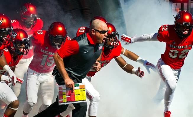 UNLV head coach Tony Sanchez runs onto the field with his players as they take on Boise State on Saturday, Oct. 31, 2015, at Sam Boyd Stadium.