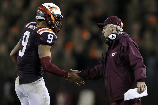 Virginia Tech quarterback Brenden Motley, left, is congratulated by head coach Frank Beamer after his second touchdown pass against North Carolina State on Friday, Oct. 9, 2015, during the first half of an NCAA college football game in Blacksburg, Va. 