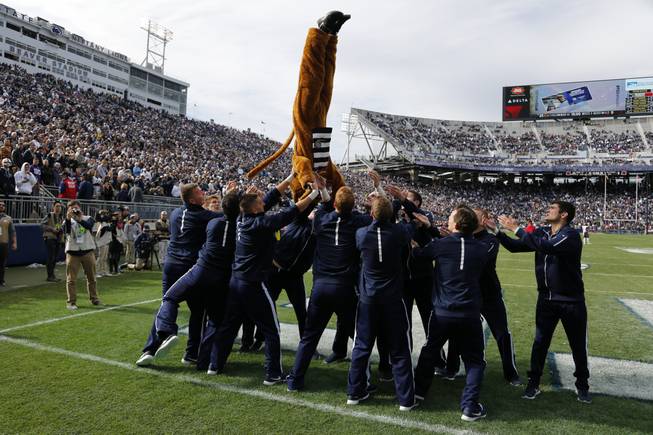 Penn State cheerleaders toss the Penn State Mascot, the Nittany Lion, as they celebrate a touchdown during the second half of an NCAA college football game against Illinois in State College, Pa., Saturday, Oct. 31, 2015. Penn State won 39-0.