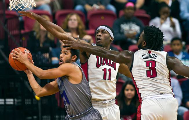 Whittier guard Anthony Martinez (11) looks for an outlet pass under heavy defense by UNLV forward/center Goodluck Okonoboh (11) and guard Jordan Cornish (3) during their game at the Thomas & Mack Center on Friday, November 6, 2015.  L.E. Baskow.