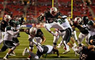 UNLV's Lexington Thomas (3) leaps over a Hawaii defender into the end zone securing the win at Sam Boyd Stadium on Saturday, November 7, 2015.