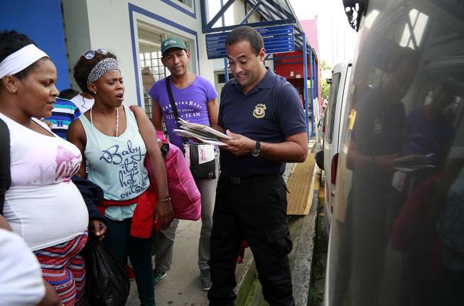 Cuban migrants who were detained by immigration police wait to board a bus that will take them to the Nicaraguan border, in San Jose, Friday, Nov. 13, 2015. Authorities in Costa Rica say they will issue special seven-day transit visas to 1,600 Cuban migrants who have been detained in recent days after crossing over from Panama. 