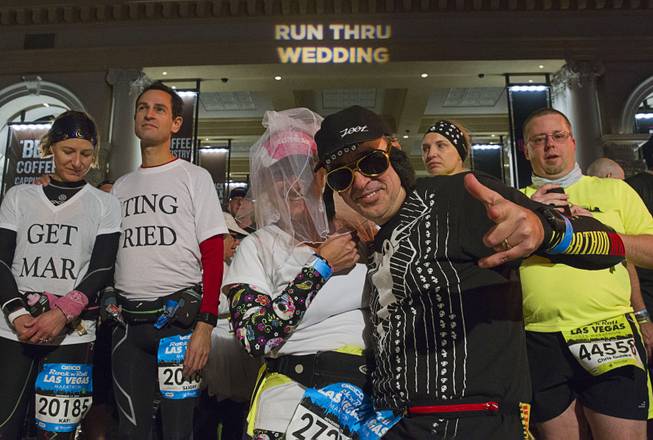 Cheryl Ano, center, and her husband Kelly, of Sylvan Beach, N.Y., wait to renew their wedding vows in a "Run Thu Wedding Ceremony" during the Geico Rock 'n' Roll Las Vegas Marathon on the Las Vegas Strip Sunday, Nov. 15, 2015. Over 150 couples got married or renewed vows during the ceremony, an organizer said.