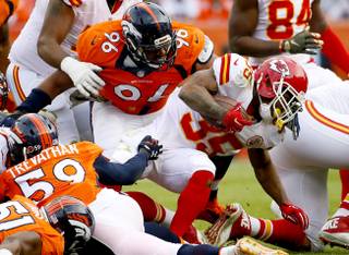 Kansas City Chiefs running back Charcandrick West (35) is stopped by Denver Broncos defensive end Vance Walker (96) during the first half of an NFL football game,  Sunday, Nov. 15, 2015, in Denver. (AP Photo/Jack Dempsey)