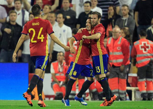 Spain’s Santiago Cazorla, center, celebrates with Juan Manuel Mata, right, after scoring his side’s second goal during an international friendly soccer match between Spain and England at the Rico Perez Stadium in Alicante, Spain, Friday, Nov. 13, 2015. 