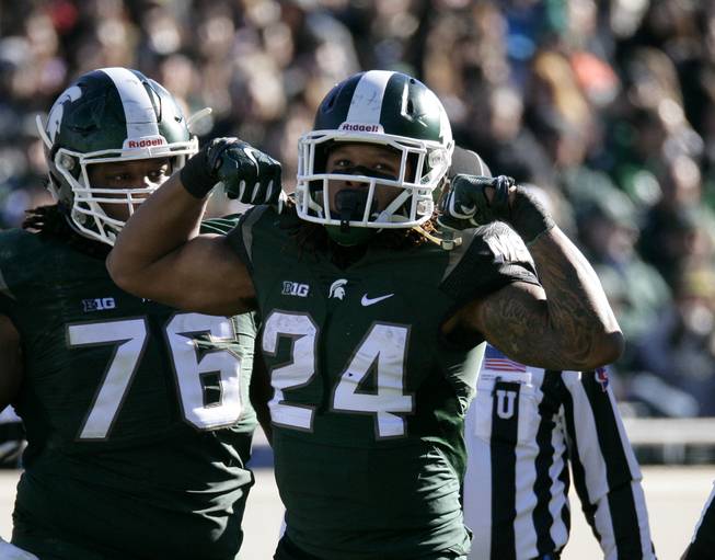 Michigan State's Gerald Holmes (24) celebrates during the second quarter of an NCAA college football game against Maryland, Saturday, Nov. 14, 2015, in East Lansing, Mich. Michigan State won 24-7.