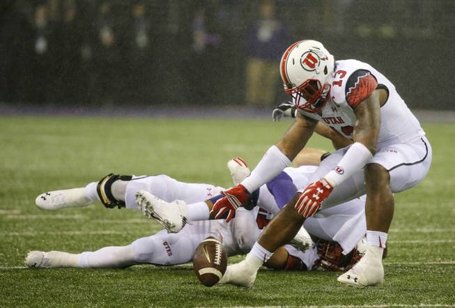 Utah linebacker Gionni Paul (13) recovers a fumble by Washington fullback Dwayne Washington during the first half of an NCAA football game Saturday, Nov. 7, 2015, in Seattle. Paul returned the recovery 54 yards for a touchdown on the play.