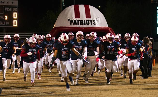 Liberty players run onto the field as they ready to meet Green Valley in their high school state quarterfinal game at Liberty on Friday, November 20, 2015.