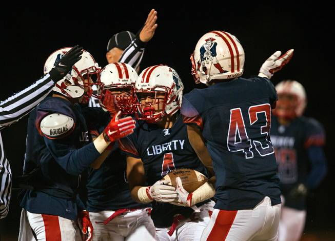 Liberty teammates celebrate a fumble recovery by Mario Garcia (4) versus Green Valley in their high school state quarterfinal game at Liberty on Friday, November 20, 2015.  .