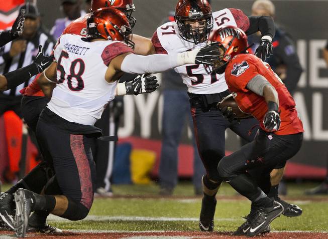 San Diego State's Alex Barrett (58) covers the face mask of UNLV's Lexington Thomas (3) just prior to his fumble during their game at Sam Boyd Stadium. 