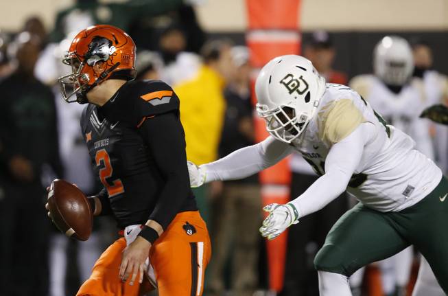 Baylor linebacker Aiavion Edwards, right, moves in to sack Oklahoma State quarterback Mason Rudolph (2) in the second quarter.
