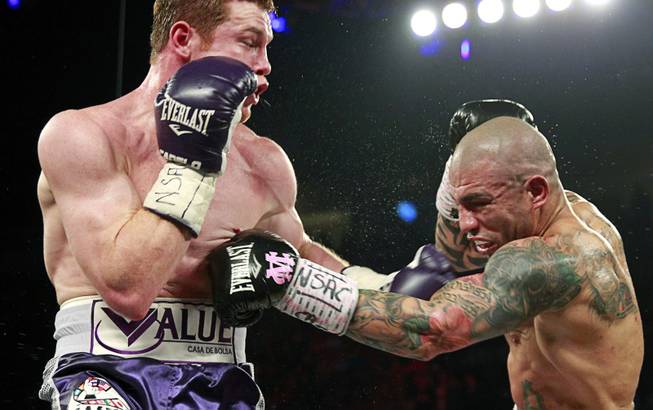 Canelo Alvarez, left, of Mexico battles with Miguel Cotto of Puerto Rico during their middleweight fight at the Mandalay Bay Events Center Saturday, Nov. 21, 2015.