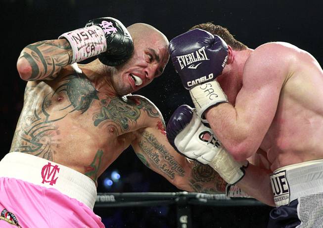 Miguel Cotto, left, of Puerto Rico battles with Canelo Alvarez of Mexico during their middleweight fight at the Mandalay Bay Events Center Saturday, Nov. 21, 2015. Alvarez beat Cotto to win the WBC middleweight title.