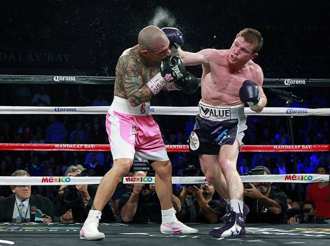 Canelo Alvarez, right, of Mexico connects on Miguel Cotto of Puerto Rico during their middleweight fight at the Mandalay Bay Events Center Saturday, Nov. 21, 2015.