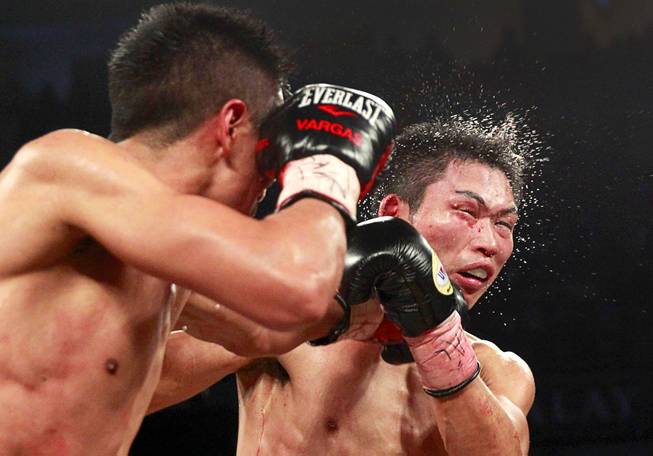 WBC super featherweight champion Takashi Miura, right,  of Japan takes a punch from Francisco Vargas of Mexico during their title fight at the Mandalay Bay Events Center Saturday, Nov. 21, 2015.