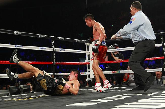 Francisco Vargas, right, of Mexico knocks down WBC super featherweight champion Takashi Miura of Japan during their title fight at the Mandalay Bay Events Center Saturday, Nov. 21, 2015. Referee Tony Weeks is at right.