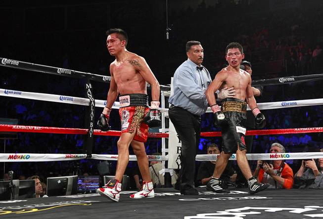 Referee Tony Weeks sends sends WBC super featherweight champion Takashi Miura, right, of Japan and Francisco Vargas of Mexico to their corners at the end of the eight round at the Mandalay Bay Events Center Saturday, Nov. 21, 2015.