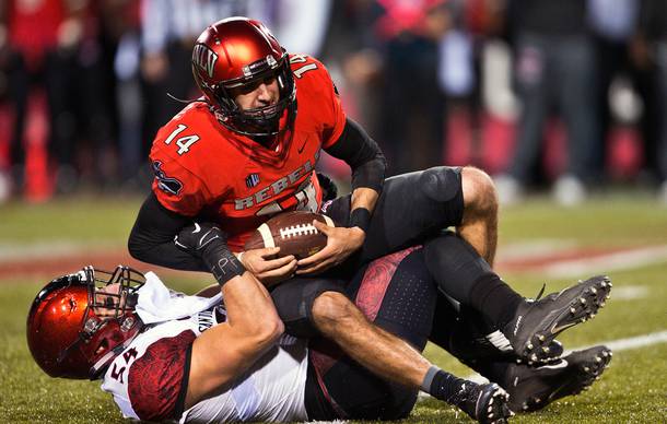 UNLV QB Kurt Panandech (14) is thrown for a loss by San Diego State's Calvin Munson (54) during their game at Sam Boyd Stadium on Friday, November 21, 2015.