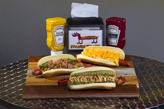 Specialty dogs at the Steamie Weenie, 1500 N Green Valley Parkway, in the Pebble Marketplace in Henderson Sunday, Nov. 22, 2015.  Clockwise from top right: The Mac & Cheese & Cheese, PBB&JJ (bacon wrapped dog with peanut butter and jalapeno jelly), and the 9th Island.