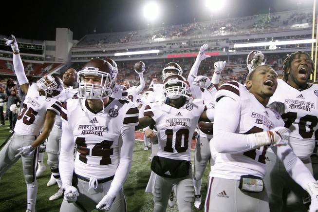 Mississippi State players celebrate with fans after an NCAA college football game against Arkansas, Saturday, Nov. 21, 2015, in Fayetteville, Ark. 