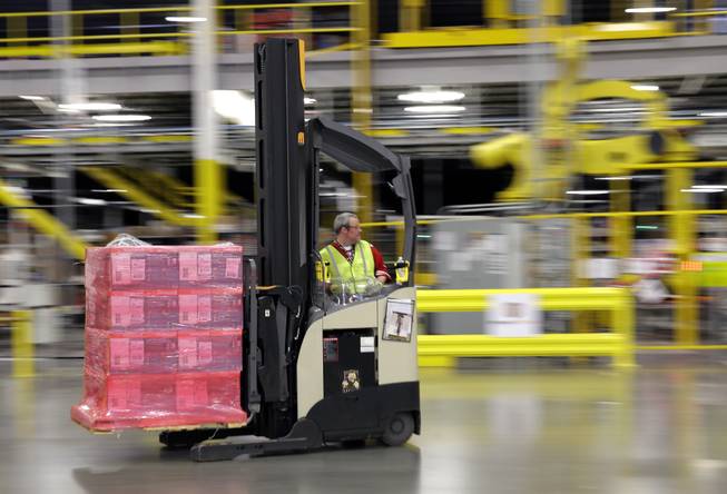 In this Feb. 13, 2015, file photo, a forklift operator moves a pallet of goods at an Amazon.com fulfillment center in DuPont, Wash. This year, Amazon has been making an aggressive push to offer same-day delivery to its $99 annual Prime loyalty club members. Their service is now available in 750 cities and towns in 16 metro areas. And where Amazon goes, other retailers must follow.