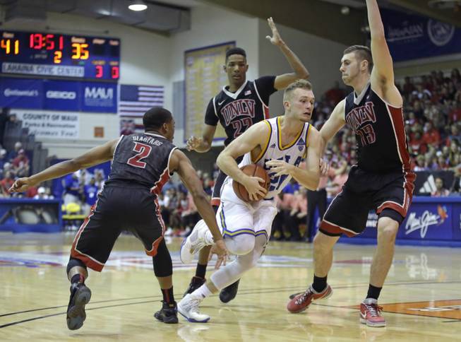 UCLA guard Bryce Alford (20) drives through UNLV's Jerome Seagears (2), Patrick McCaw (22) and Ben Carter (13) in the second half of a basketball game in the first round of the Maui Invitational on Monday, Nov. 23, 2015, in Lahaina, Hawaii. UCLA won 77-75.