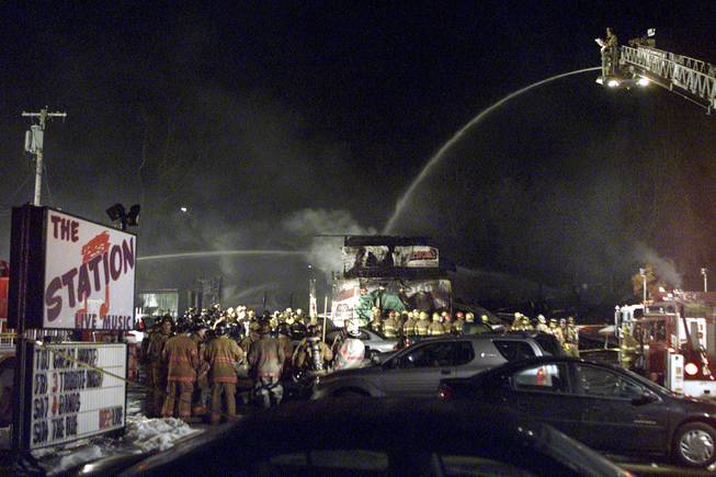 Firefighters spray water in February 2003 on to the charred nightclub The Station, where 100 people were killed and more than 200 people were injured in West Warwick, R.I.