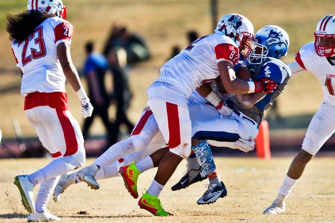 Liberty's Cyrius Vea (82) puts a big hit on Basic's Harris Frank (16) after a reception during their high school state semifinals football game at Basic Academy of International Studies on Saturday, November 28, 2015.