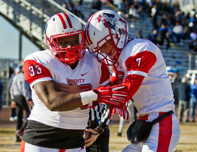 Liberty's Calvin Tubbs (33) celebrates his score with Liberty QB Kenyon Oblad (7) during their high school  state semifinals football game at Basic Academy of International Studies on Saturday, November 28, 2015.