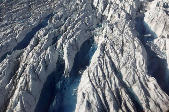 In this July 19, 2011, file photo, pools of melted ice form atop Jakobshavn Glacier near the edge of the vast Greenland ice sheet. Since 1997, the West Antarctic and Greenland ice sheets have lost 5.5 trillion metric tons of ice, according to Andrew Shepherd at the University of Leeds, who used NASA and European satellite data. 