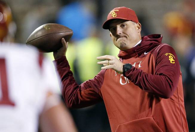 In this Nov. 13, 2015, photo, Southern California interim head coach Clay Helton throws a football in the first half of an NCAA football game against Colorado in Boulder, Colo. USC hired Helton as its permanent coach Monday, removing the interim tag after he guided the team to a division title since taking over for Steve Sarkisian. 