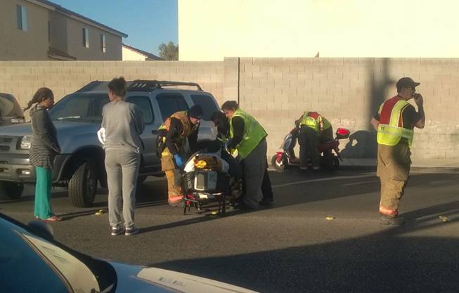 A person is seen on a stretcher after a collision between a motor scooter and a vehicle on Monday, Nov. 30, 2015, at the intersection of South Duneville Street and West Reno Avenue, near Jydstrup Elementary School.