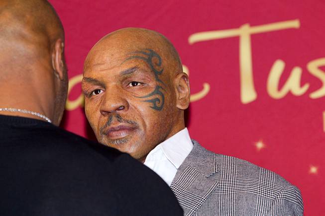 Former heavyweight boxing champion Mike Tyson, left, faces off with the world's first Mike Tyson wax figure during the figure's unveiling Tuesday, Dec. 1, 2015, at Madame Tussauds Las Vegas. The figure is modeled after Tyson’s appearance as himself in “The Hangover.” The figure will be permanently displayed inside the attraction’s “The Hangover Experience” exhibit.
