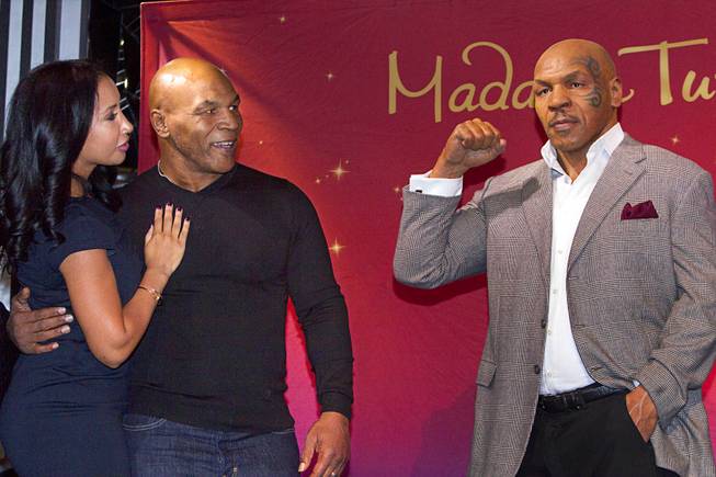 Former heavyweight boxing champion Mike Tyson and his wife Kiki look over the world's first Mike Tyson wax figure during the figure's unveiling Tuesday, Dec. 1, 2015, at Madame Tussauds Las Vegas. The figure is modeled after Tyson’s appearance as himself in “The Hangover.” The figure will be permanently displayed inside the attraction’s “The Hangover Experience” exhibit.