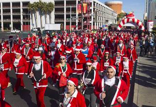 Runners dressed as Santa Claus head southbound on Las Vegas Boulevard during the 11th annual Las Vegas Great Santa Run in downtown Las Vegas, Dec. 5, 2015. The Las Vegas run competes with a run in Liverpool, England to see who can gather the largest number of Santas. The run benefits Opportunity Village with provides support to people with intellectual disabilities and their families.