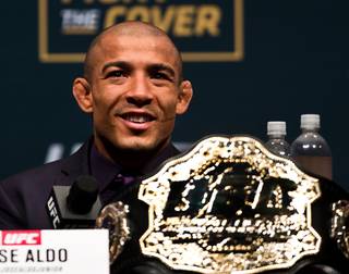 UFC featherweight champion Jose Aldo smiles in response to his challenger's response during the UFC 194 press conference at the MGM Grand Garden Arena in Las Vegas on Wednesday, December 9, 2015.