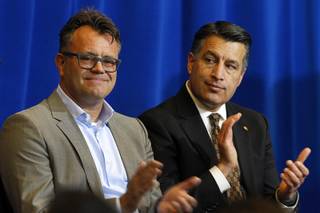 Dag Reckhorn, left, global vice president of manufacturing for Faraday Future, and Nevada Governor Brian Sandoval applaud during a news conference at the Sawyer State Building in Las Vegas Thursday, Dec. 10, 2015. Reckhorn and the governor discussed plans for the Faraday Future electric-car factory in the city of North Las Vegas.