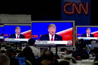Businessman Donald Trump is shown on monitors in the press room during the Republican Presidential Debate at the Venetian Tuesday Dec. 15, 2015.
