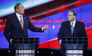 George Pataki, left, makes a point as Mike Huckabee looks on during the CNN Republican presidential debate at the Venetian Hotel & Casino on Tuesday, Dec. 15, 2015, in Las Vegas.