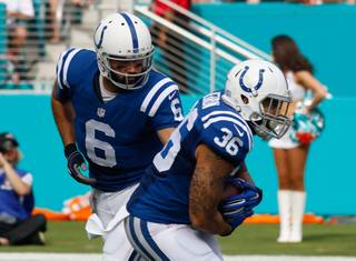 Indianapolis Colts quarterback Charlie Whitehurst (6) hands the ball to running back Dan Herron (36) during the first half of an NFL football game, Sunday, Dec. 27, 2015, in Miami Gardens, Fla.  (AP Photo/Joe Skipper)