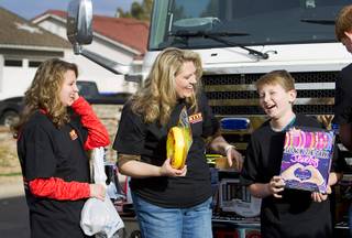 Members of the Cain family, from left, Sarah, 13, mother Sanna, and Michael, 11, look over presents during an Operation FireH.E.A.T. (Holiday Emergency Assistance Team) event in Henderson Sunday, Jan. 3, 2016. The firefighter charity brought Christmas presents to the Cain family who lost everything when their home was destroyed by fire on Dec. 28.